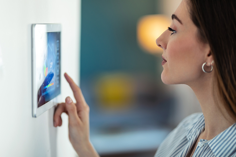 woman using the home security system on digital table
